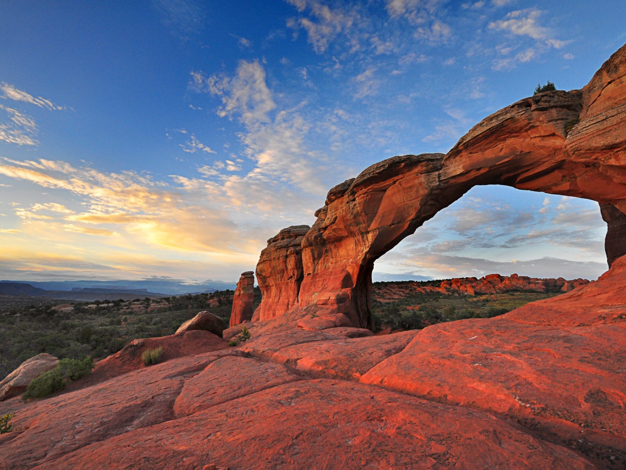 a natural arch with a mountain in the background