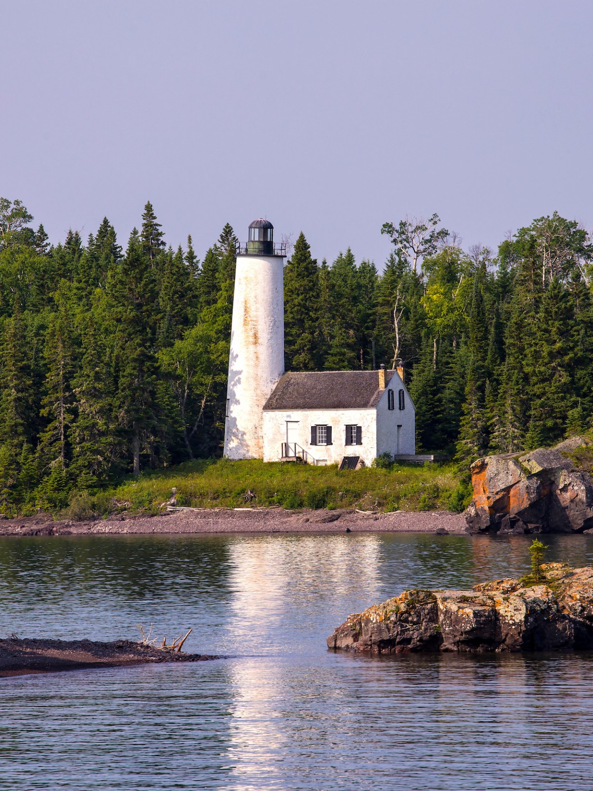 a small boat in a body of water surrounded by trees
